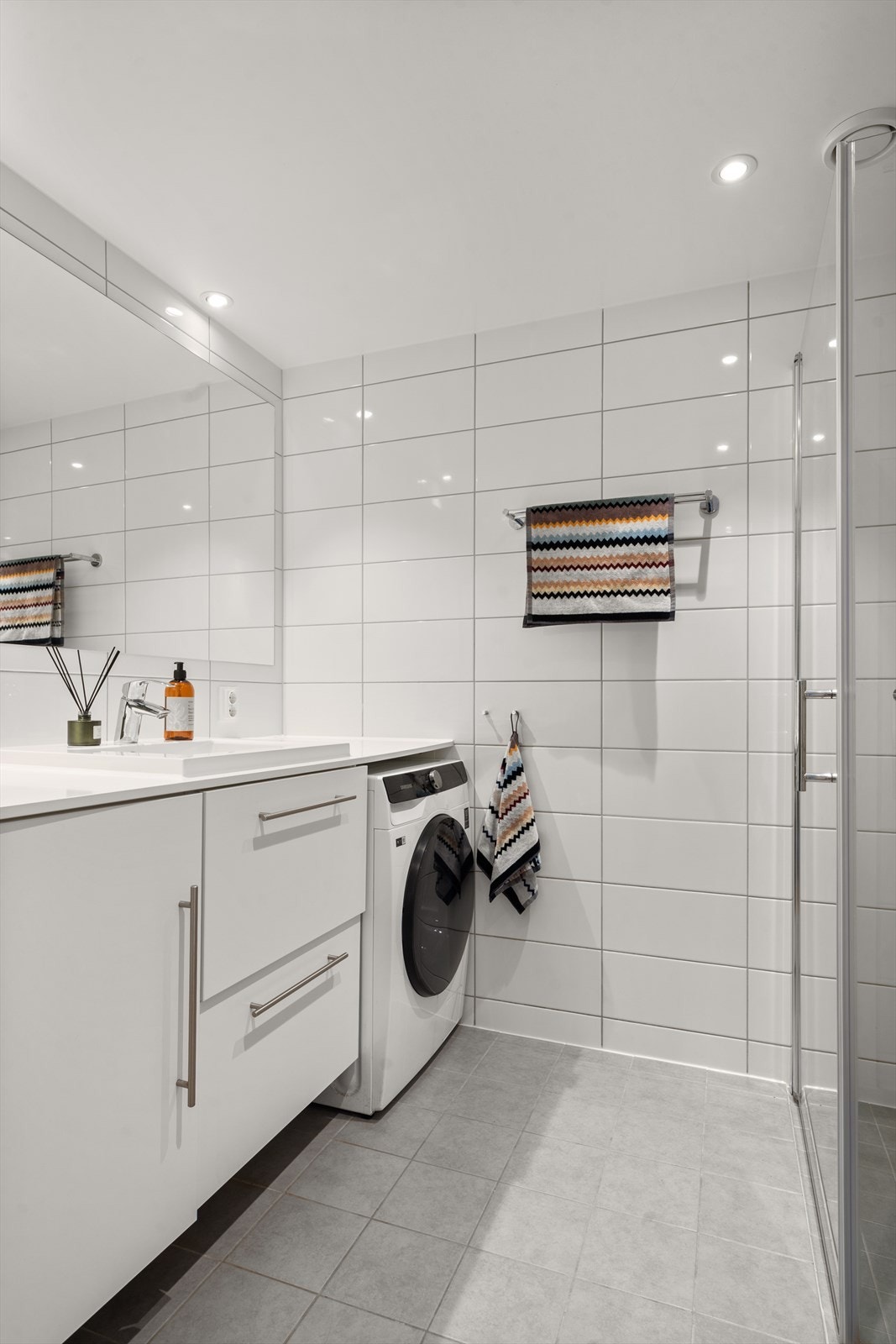 Lyst og pent flislagt bad fra 2021 med gulvvarme og downlights i himling. Galleribilde