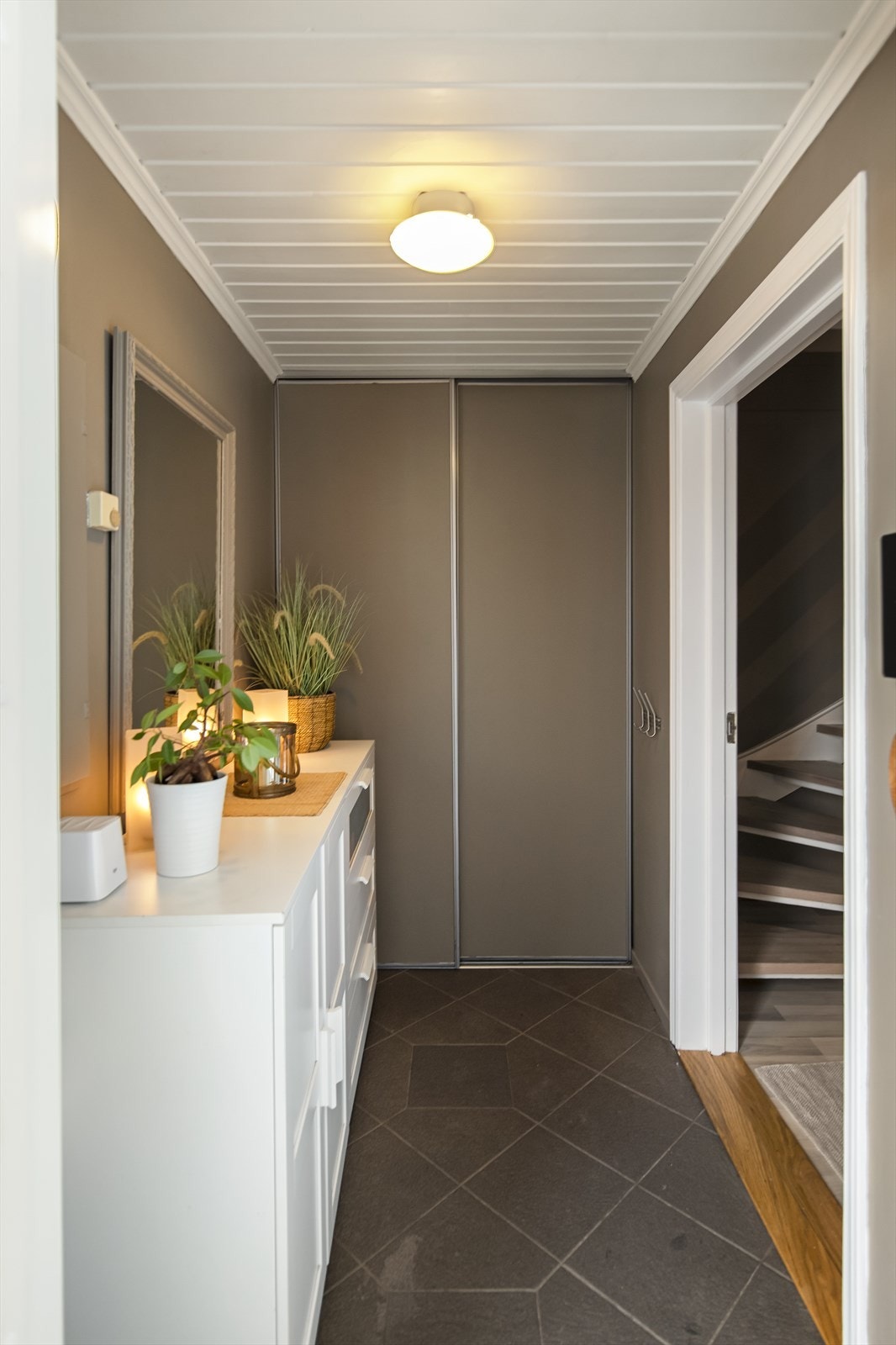 God skyvedørsgarderobe i entreen. Fliser på gulv med varmekabler Galleribilde