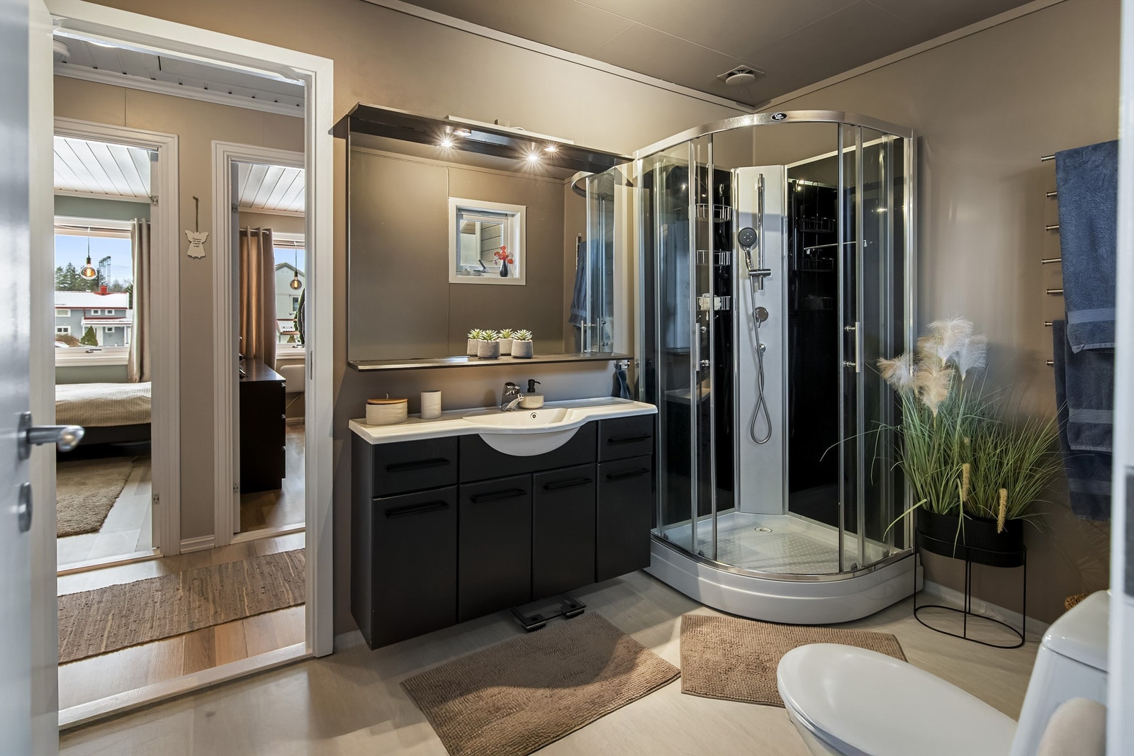 Badet er innredet med dusjkabinett, toalett og servant i innredning Galleribilde