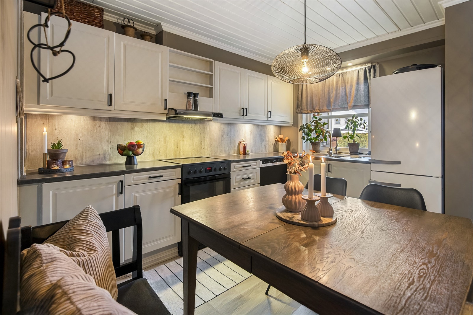 Koselig og innbydende kjøkken med profilerte fronter, sorte detaljer og backsplash på vegg Galleribilde