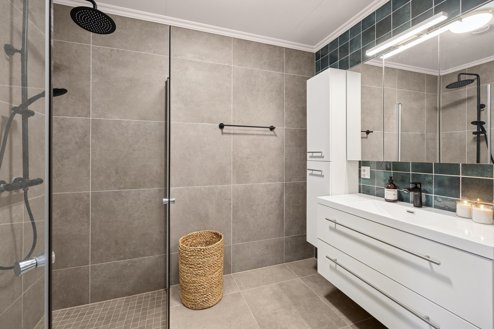 Baderommet har flislagte vegger og gulv med elektriske varmekabler. Innredet med dusj, servant med innredning, speil og belysning. Galleribilde