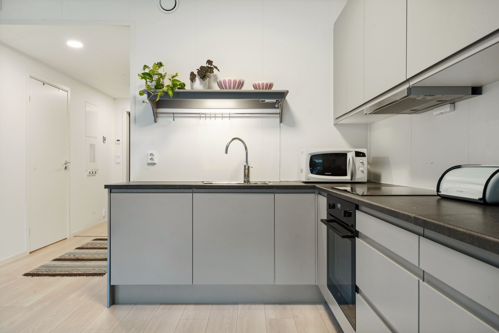 Pent kjøkkeninnredning fra Sigdal med integrerte hvitevarer. Galleribilde