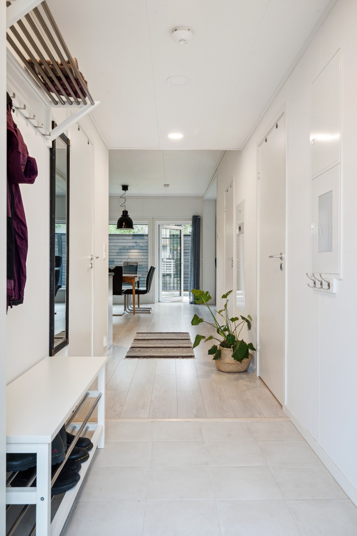 Lys entrè/gang med dør inntil bad/vaskerom og leilighets 2 soverom. Galleribilde