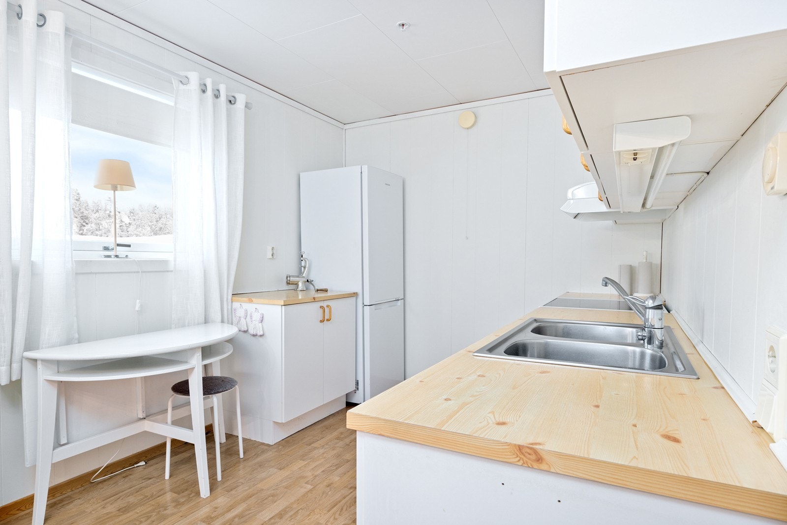 Kjøkkenet er utstyrt med en innredning med glatte fronter og en benkeplate av laminat. Galleribilde