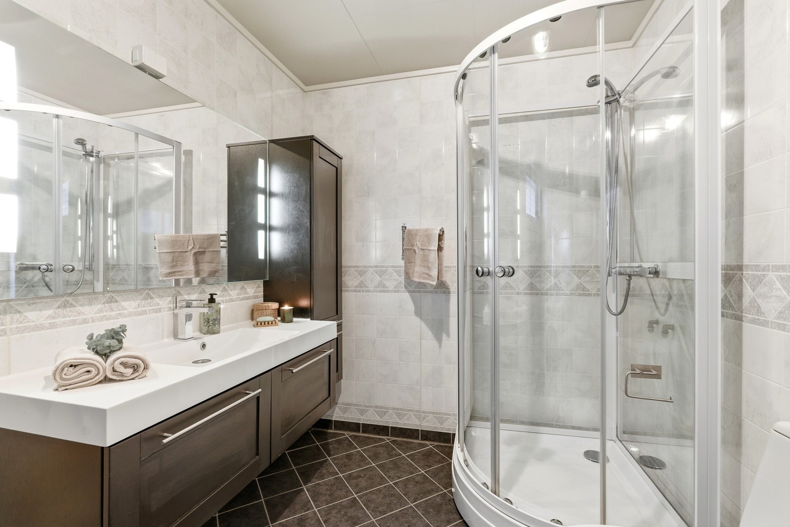 Baderomsplater på veggene og flislagt gulv med varmekabler. Galleribilde