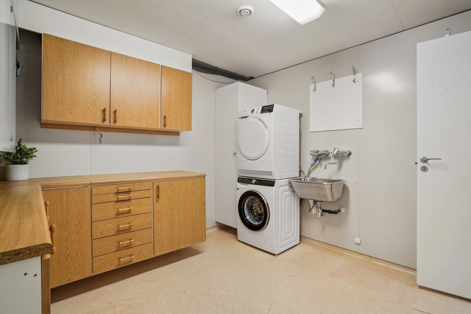 Vaskerom med innredning. Utslagsvask i stål. Opplegg for vaskemaskin. Rommet må oppgraderes for å tåle dagens bruk. Galleribilde