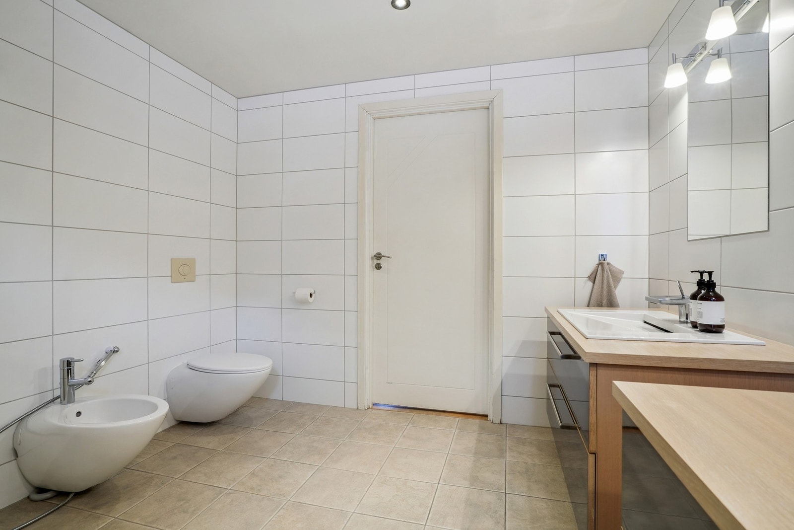 Badet er utstyrt med vegghengt toalett, bidé, og badekar med veggmontert dusjgarnityr. Galleribilde