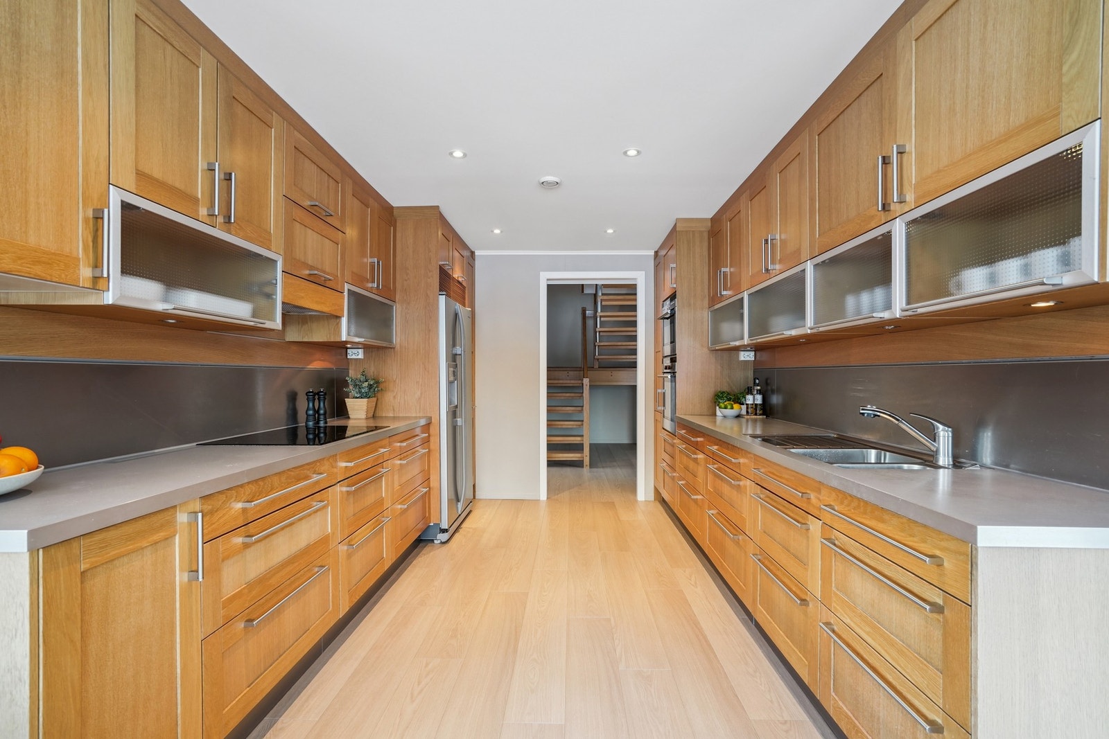 Det er vannbestandig plate på veggen over benkteplaten. Belysning under overskap. Galleribilde