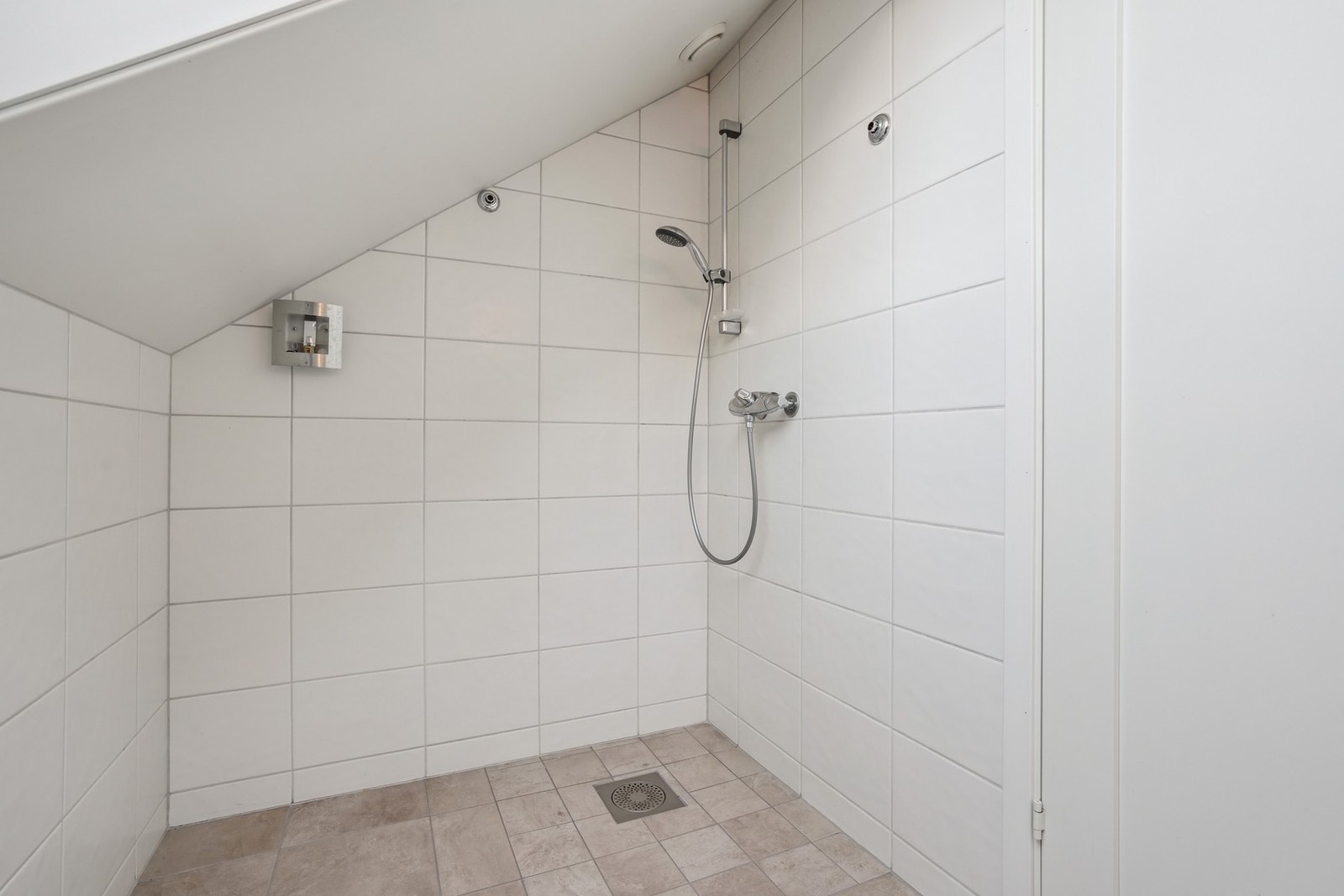 Utstyrt med vegghengt toalett og veggmontert dusjgarnityr. Galleribilde