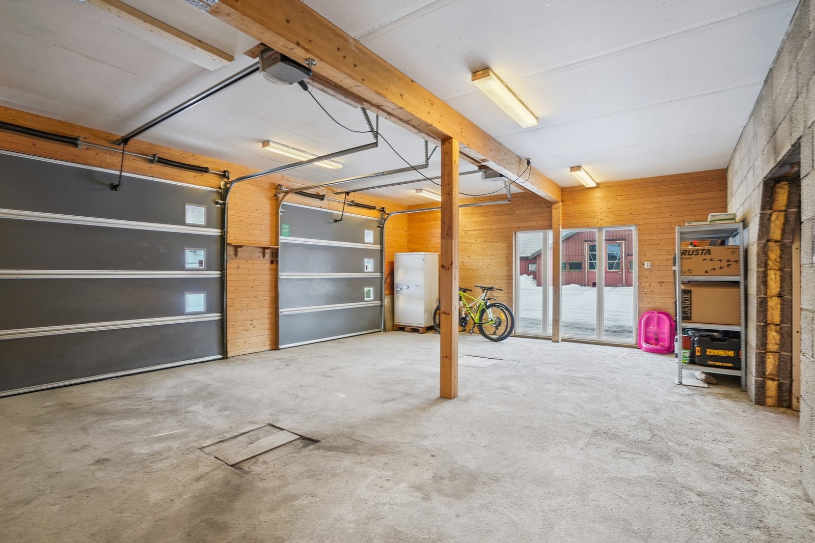 Romslig dobbel garasje med plass til to biler. Innlagt strøm, elbillader og belysning. Etablert brannkille mellom bolig og garasje i 2026. Tilkomst til teknisk rom/verksted og kjeller fra garasje. Galleribilde