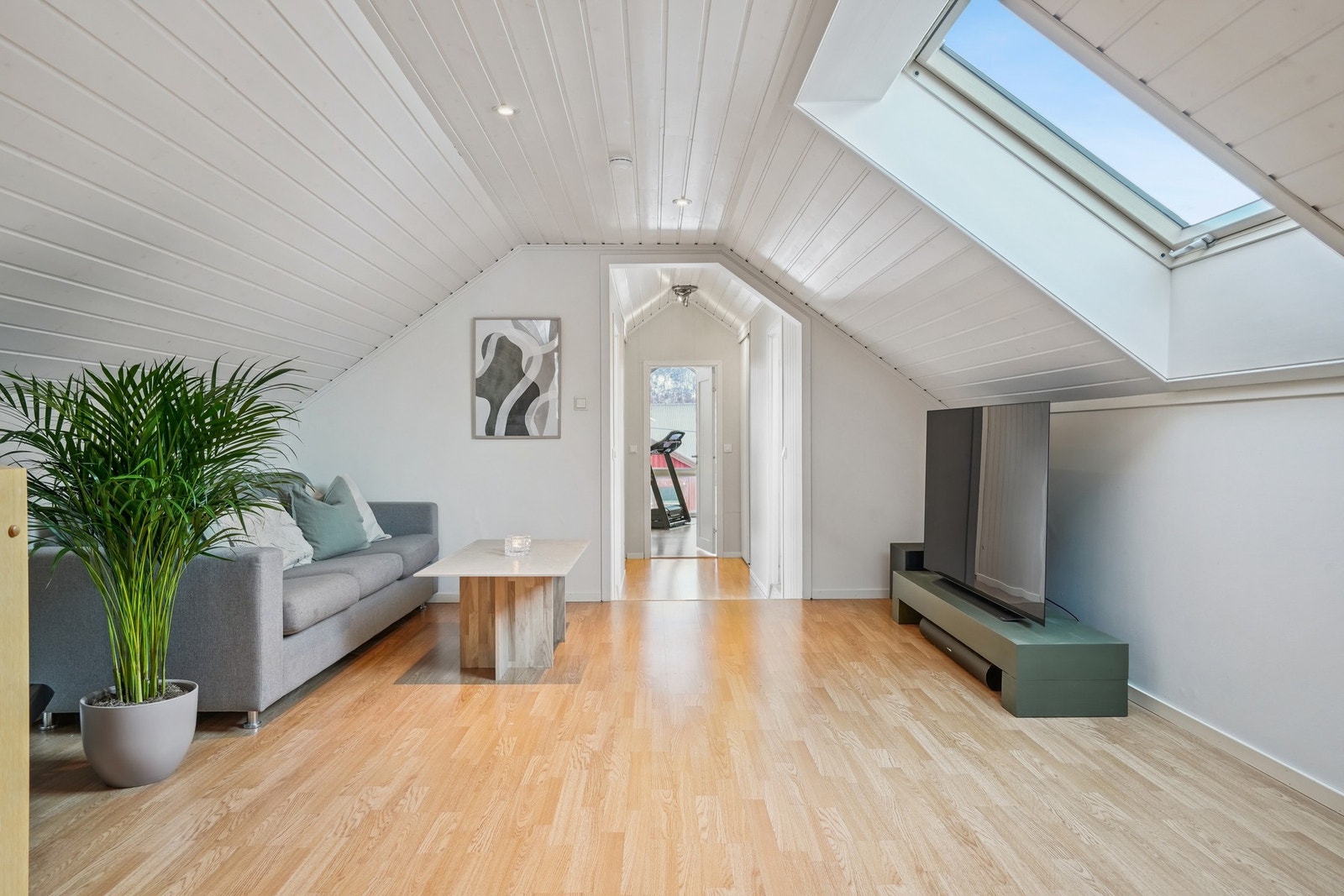 Loftstuen har god størrelse med plass til sittegruppe og tv-møblement. Ledspotter i himling. Galleribilde