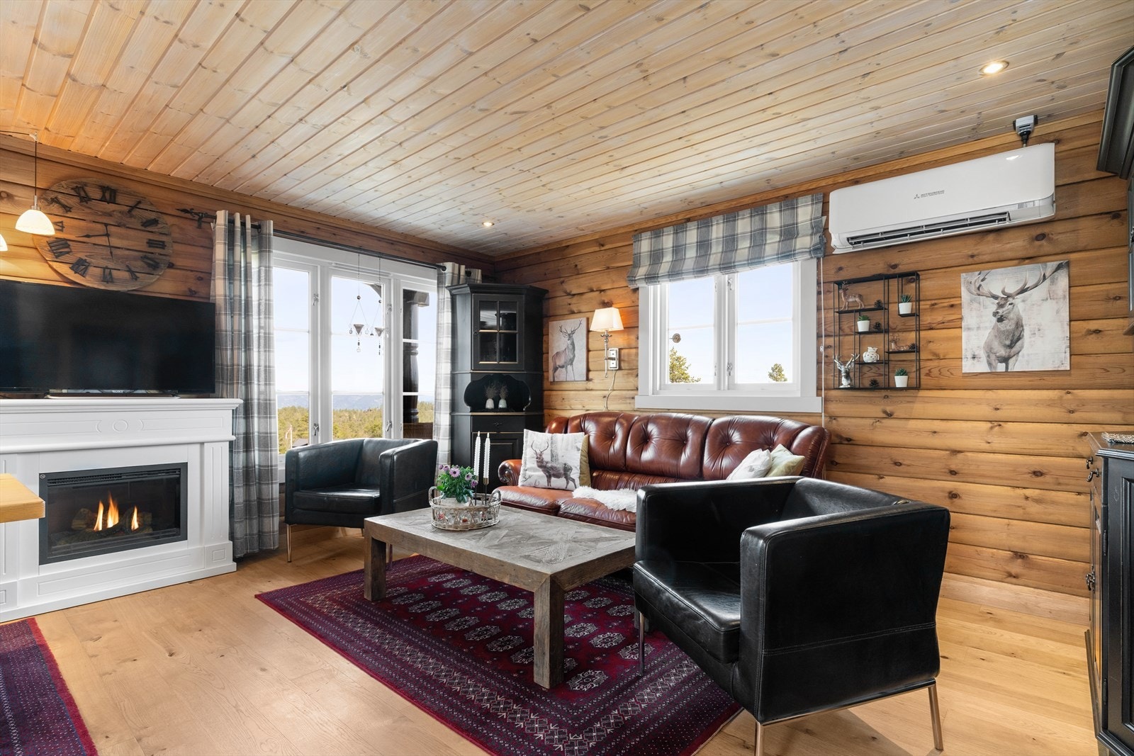 Innbydende stue med parkettbord på gulv og laftede vegger. Galleribilde