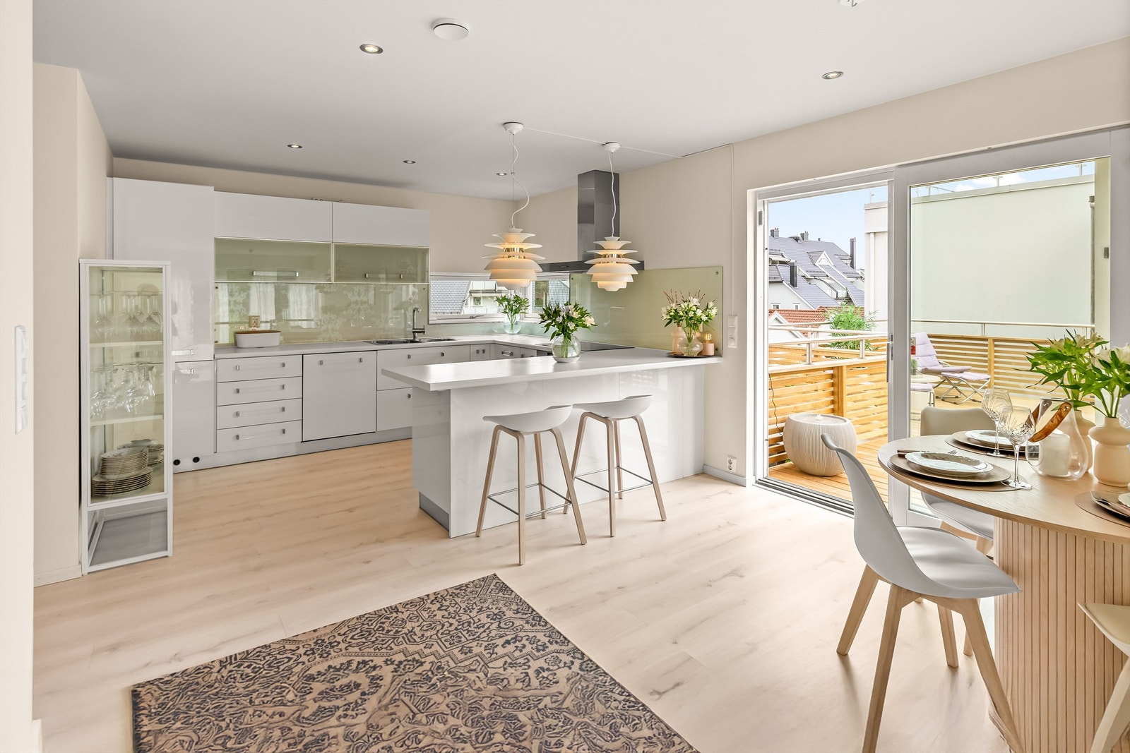 Lyst og moderne innredet kjøkken med rikelig skapplass og benkeplass Galleribilde