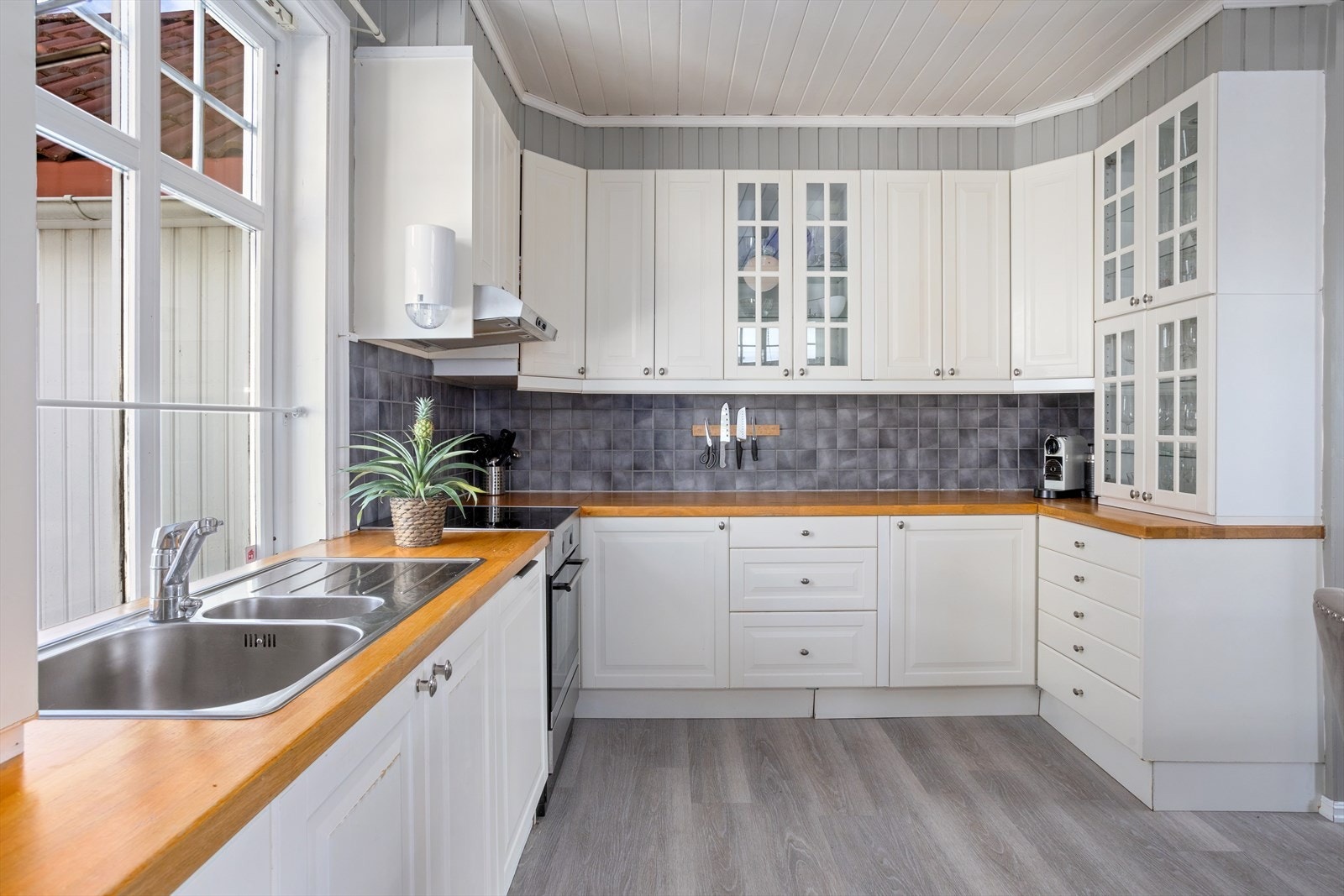 Innredningen består av profilerte fronter og fronter med glassfelt. Benkeplate i heltre med nedfelt oppvaskkum. Galleribilde