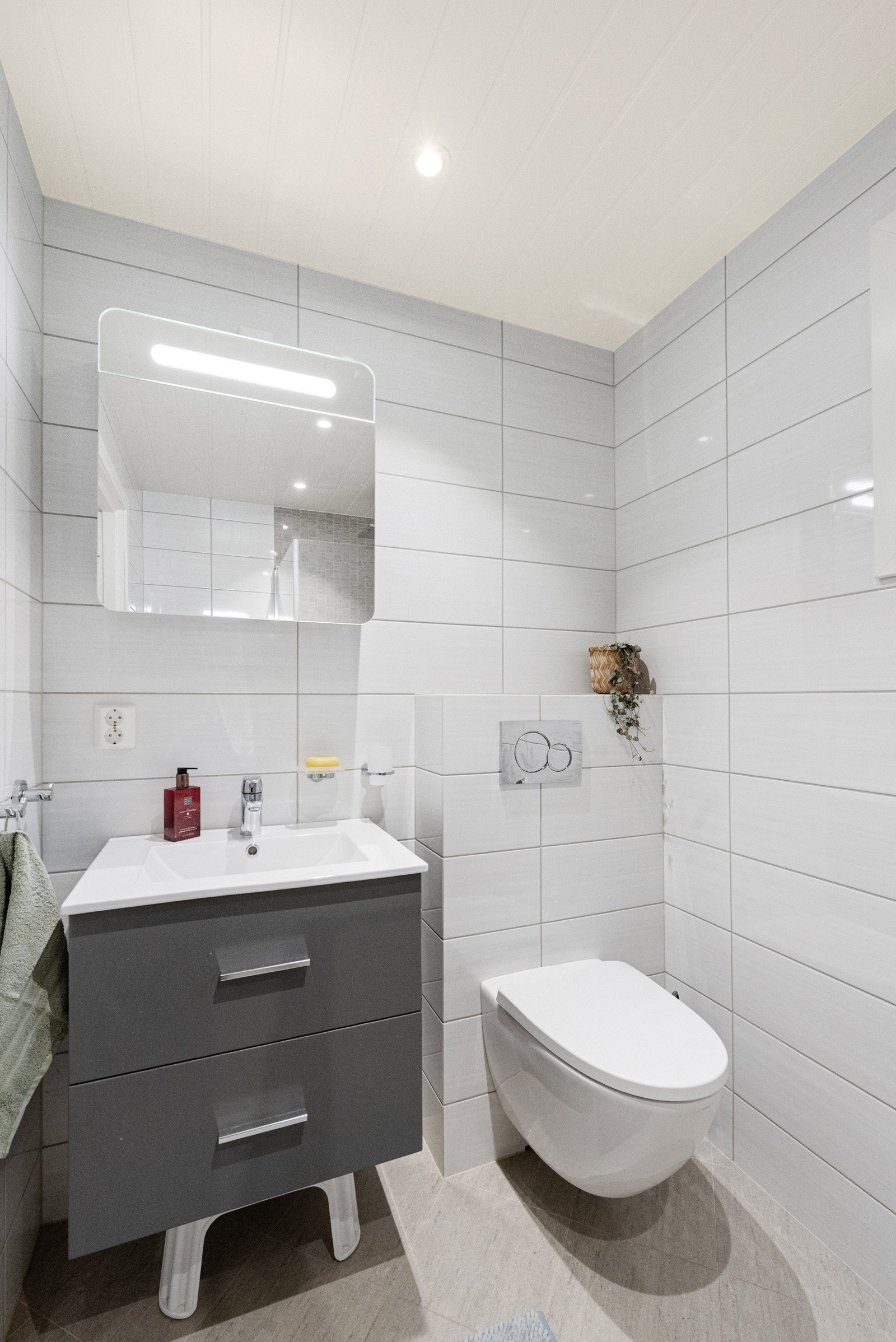 Badet ble totalrenovert i 2020 og har moderne flislagte overflater, dusjsone med foldedører, vegghengt servant med underskap og toalett. Galleribilde