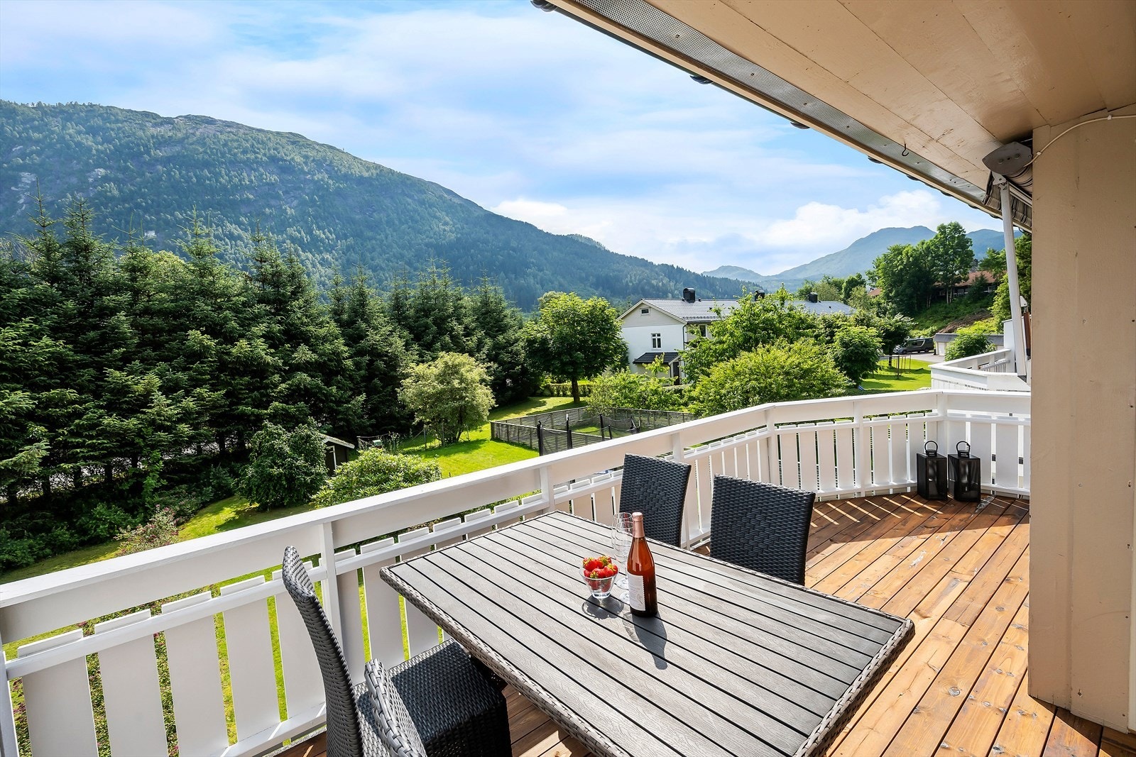 Frå stova ledar glas dør ut til romsleg og dels overbygd altan. Galleribilde