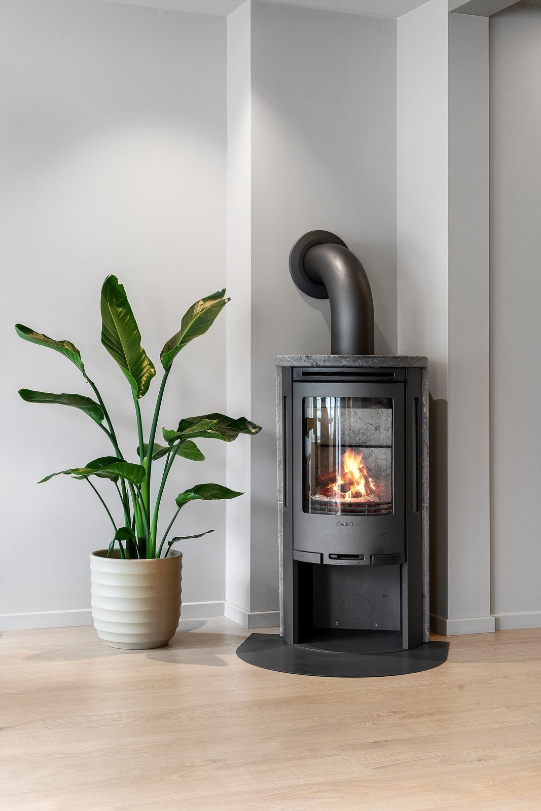 I hjørnet er det montert moderne vedomn med klebersteinselement som held godt på varmen. Galleribilde