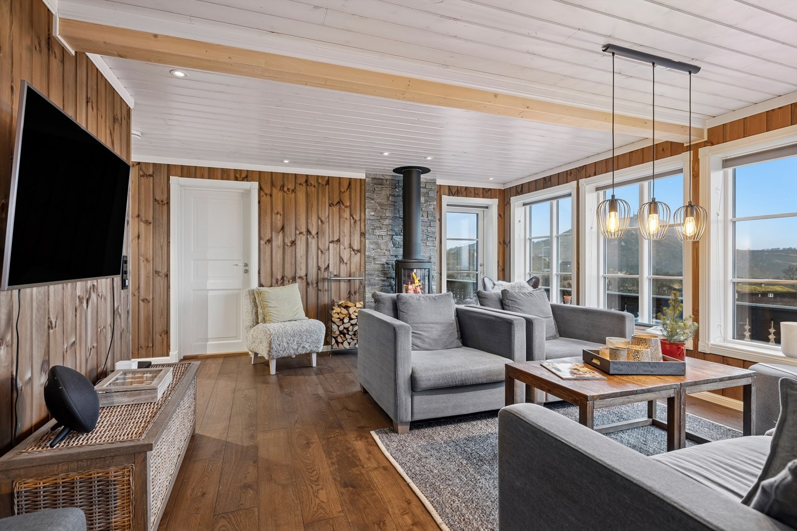 Gulvene er gjennomgående i parkett og fliser, og de varme tonene i trepanelet gir en harmonisk helhet. Galleribilde