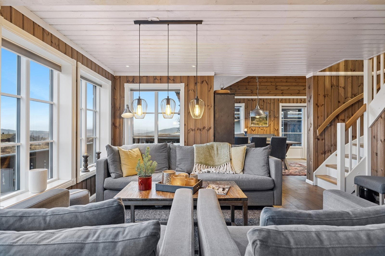 Stuen er et naturlig samlingspunkt med dagslys fra panoramavinduer som rammer inn fjellandskapet. Galleribilde