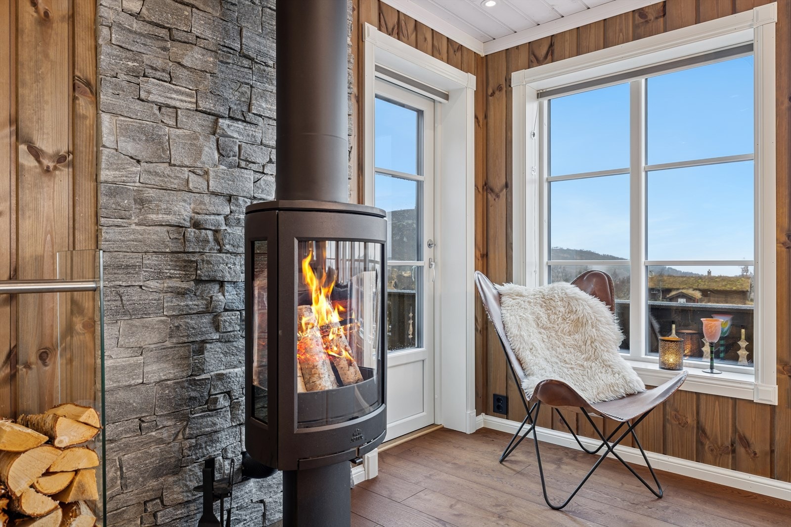 Peisen skaper et lunt og innbydende samlingspunkt i stuen - perfekt for hyggelige kvelder etter en dag ute i fjellet. Galleribilde