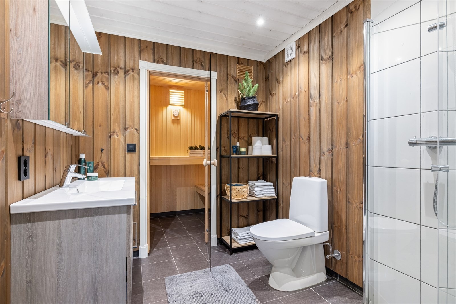 Badet i hovedetasjen er innredet med frittstående toalett, dusjhjørne og servant med skuffer og overskap med speil. Badet har direkte tilknytning til badstue. Galleribilde