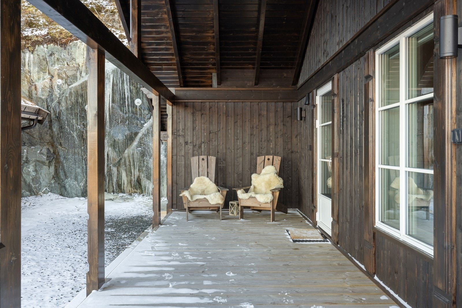 Deler av terrassen er overbygd som gir ly for vær og vind - Her fra utgangen til kjøkkenet. Galleribilde