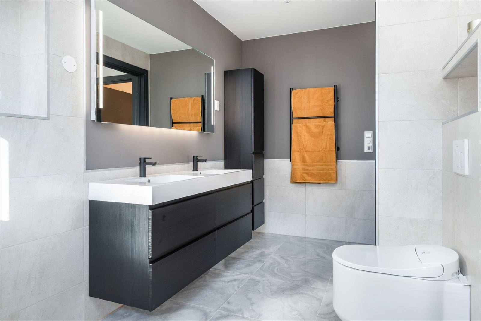 Innredningen har heldekkende dobbelvask, underskuffer med slette fronter og speil med lys. Galleribilde