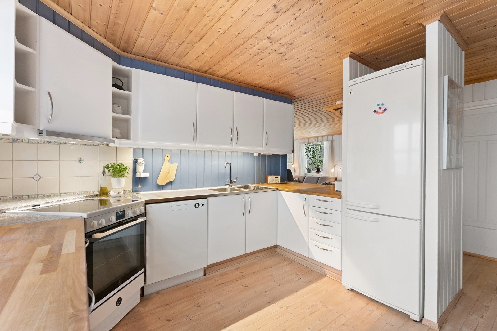 Med frittstående hvitevarer, benkeplate i tre og lyse fronter - har du et praktisk kjøkken. Galleribilde