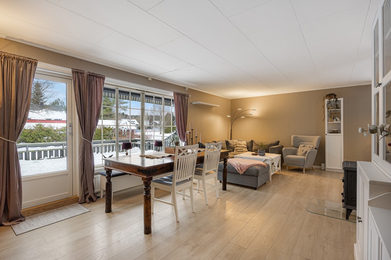 Vinduer på to sider inkluderer en glassdør fra 2022 til terrassen, og om sommeren får man et stort ekstra areal i forlengelse av stuen. Galleribilde