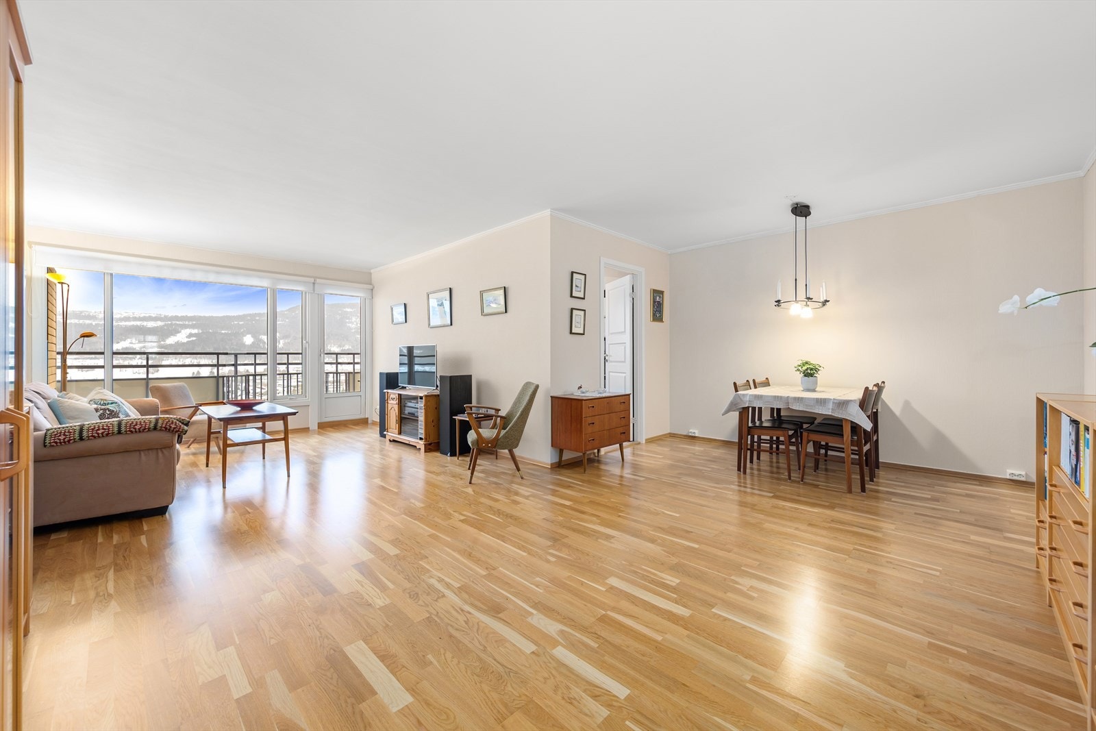 Stuen oppleves som romslig, lys og luftig med store vindusflater som slipper inn rikelig med naturlig lys gjennom hele dagen. Galleribilde