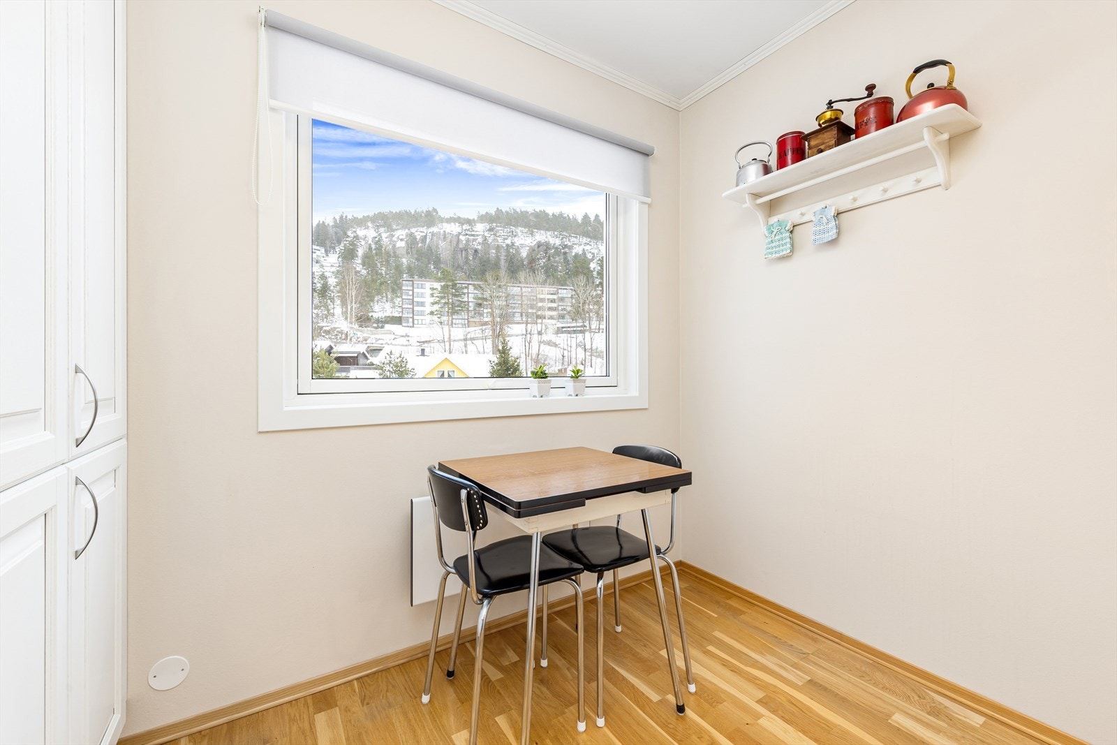 Koselig spiseplass på kjøkkenet hvor man kan starte dagen med en god frokost til en nydelig utsikt over boligområdet. Galleribilde