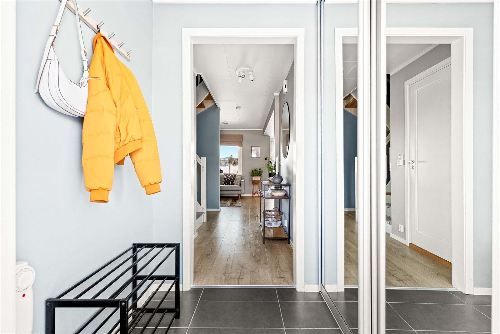 Pen entre med god plass til å henge yttertøy og sko i skyvedørsgarderobe med speil. Det er gulvvarme i entreen. Galleribilde