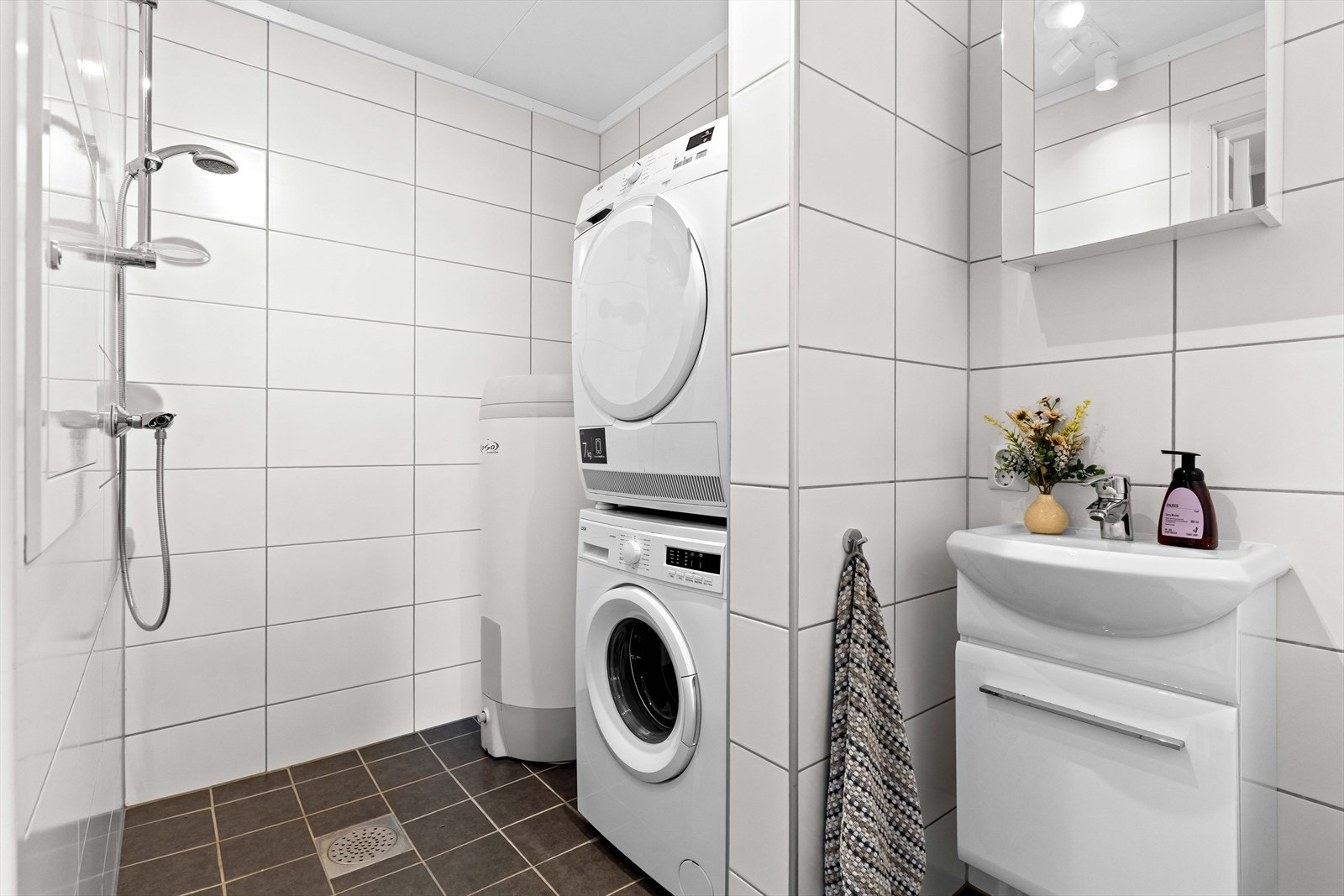 På badet er det opplegg for vaskemaskin og tørketrommel. Videre er det hånddusj på veggen. Galleribilde