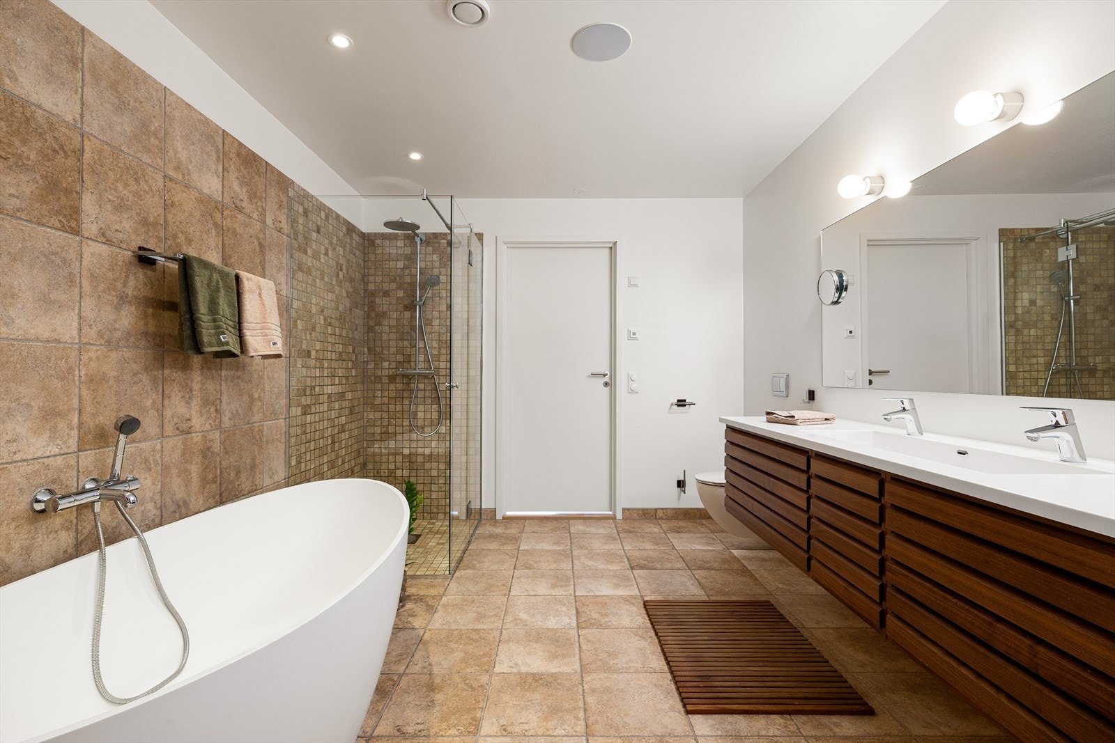 Badet er innredet med dusj, frittstående badekar i dansk design, servant med blandebatteri og vegghengt toalett. Galleribilde