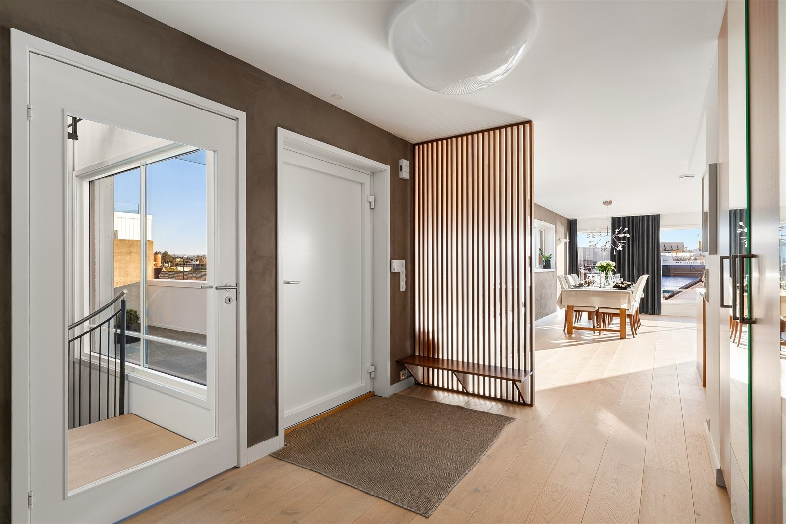 Entréen har plass til oppbevaring av yttertøy og fremstår både ryddig og funksjonell. Til høyre er det stedbygd valnøtt garderobe og valnøttspiler mot allrom Galleribilde