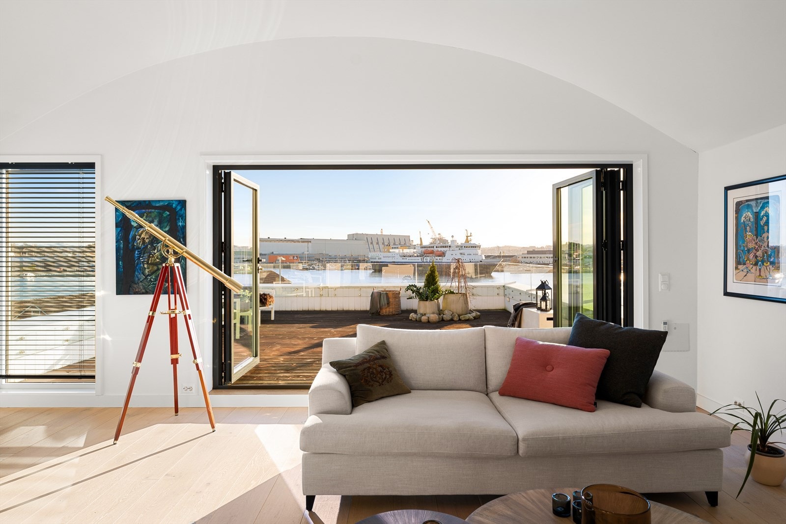 Når de store foldedørene åpnes, smelter stuen sammen med takterrassen - og utsikten over sjøen blir en del av hjemmet. Galleribilde