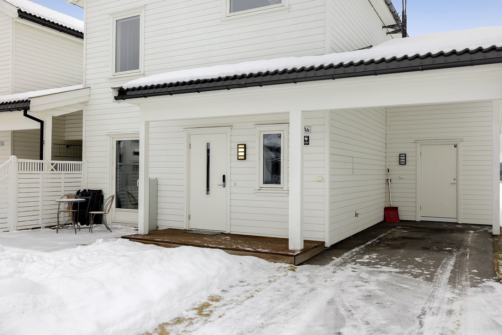 Asfaltert innkjørsel med carport, utebod og overbygget inngangsparti. Galleribilde