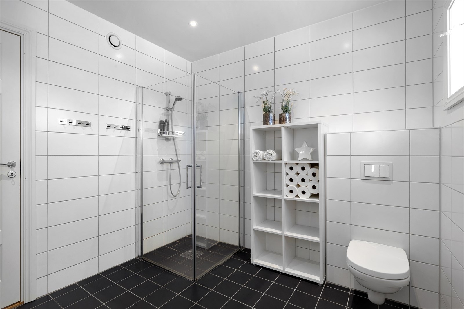 Helfliset bad med varme i gulv og downlights i himling. Vegghengt toalett og dusjhjørne med svingbare glassdører. Galleribilde