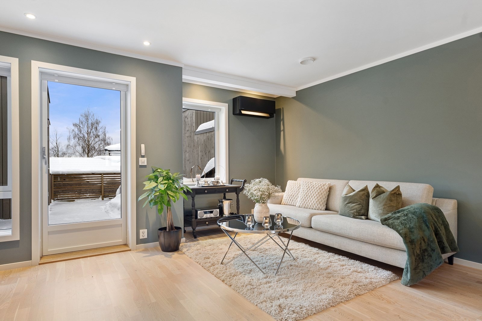 Den åpne planløsningen gir rom for flere naturlige soner, med god plass til både sofagruppe, lesekork og spisebord. På veggen er det montert varmepumpe. Galleribilde