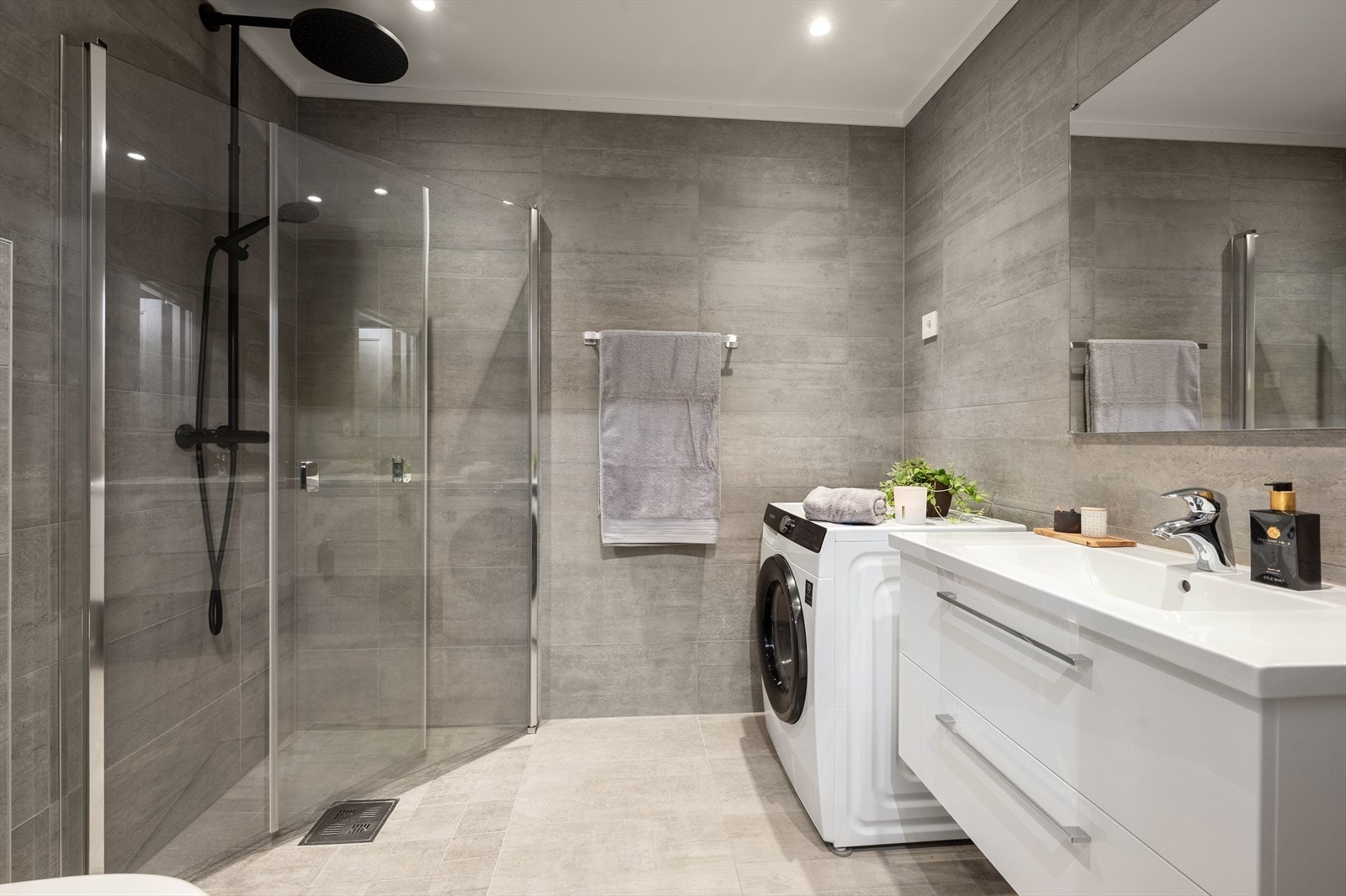 Kombinert bad og vaskerom i 1. etasje. Det er innredet med servantskap med nedfelt servant, vegghengt klosett med innebygd sisterne og romslig dusjsone med innfelte dusjdører i herdet glass. Videre er det opplegg for vaskemaskin. Galleribilde