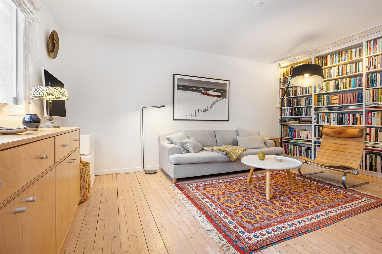 Stue med stor takhøy plassbygget bokhylle. Galleribilde