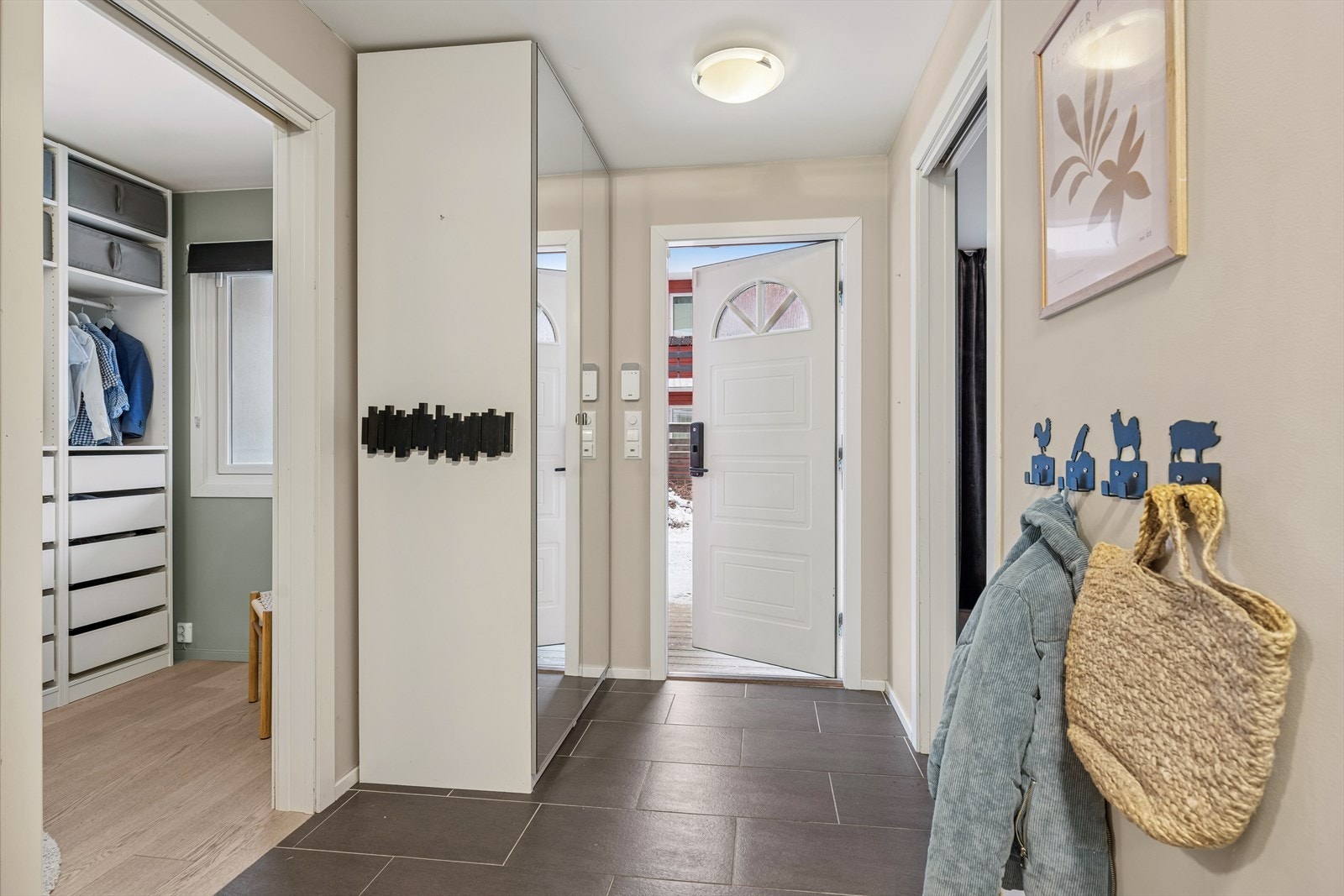 Velkommen inn i en praktisk entré med flislagt gulv og varme i gulvet. Galleribilde