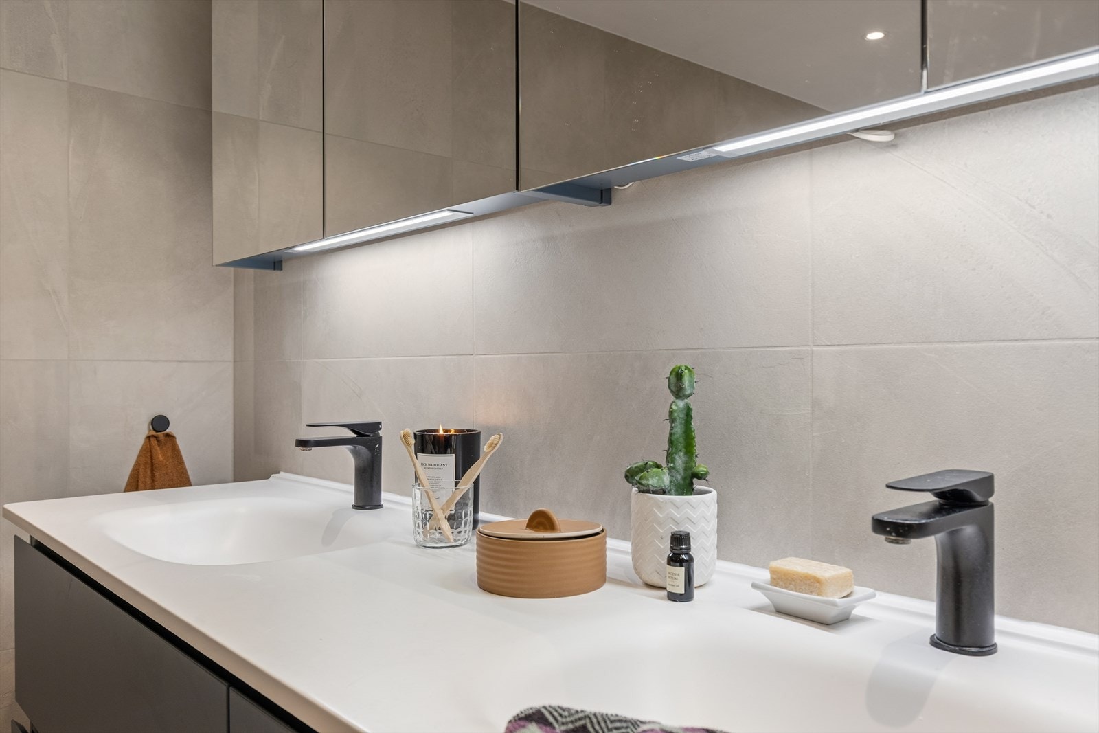 Innredningen har en bred dobbel servant med god oppbevaring i skuffer og speilskap. Galleribilde