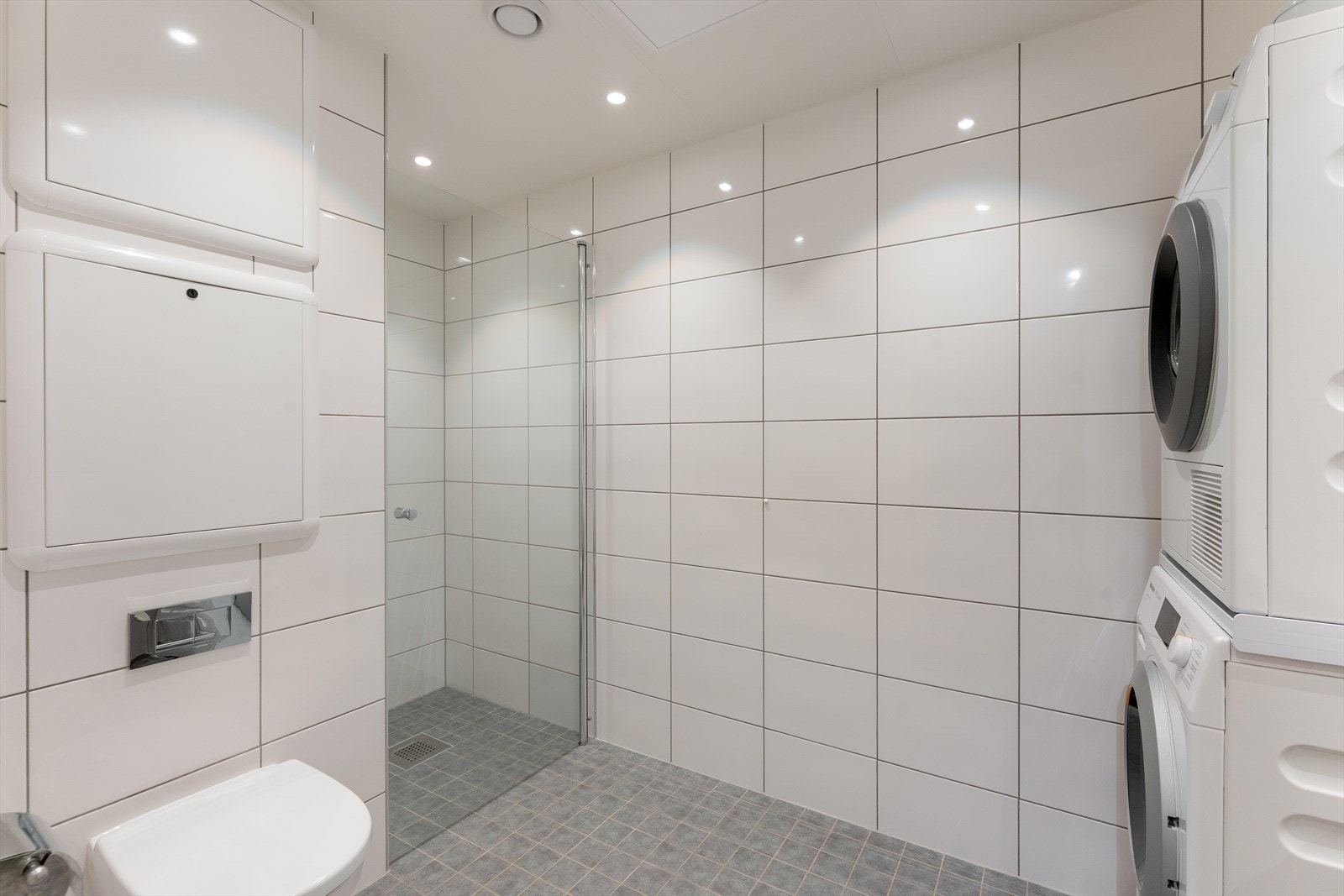 Dusjnisje med svingbar dør samt opplegg for vaskemaskin. Galleribilde