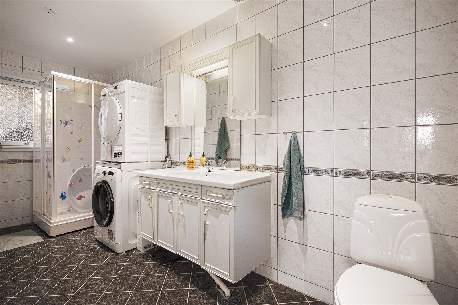 Videre finner vi badet som inneholder bla vaskemaskin, tørketrommel, dusjkabinett, servant og toalett. Galleribilde