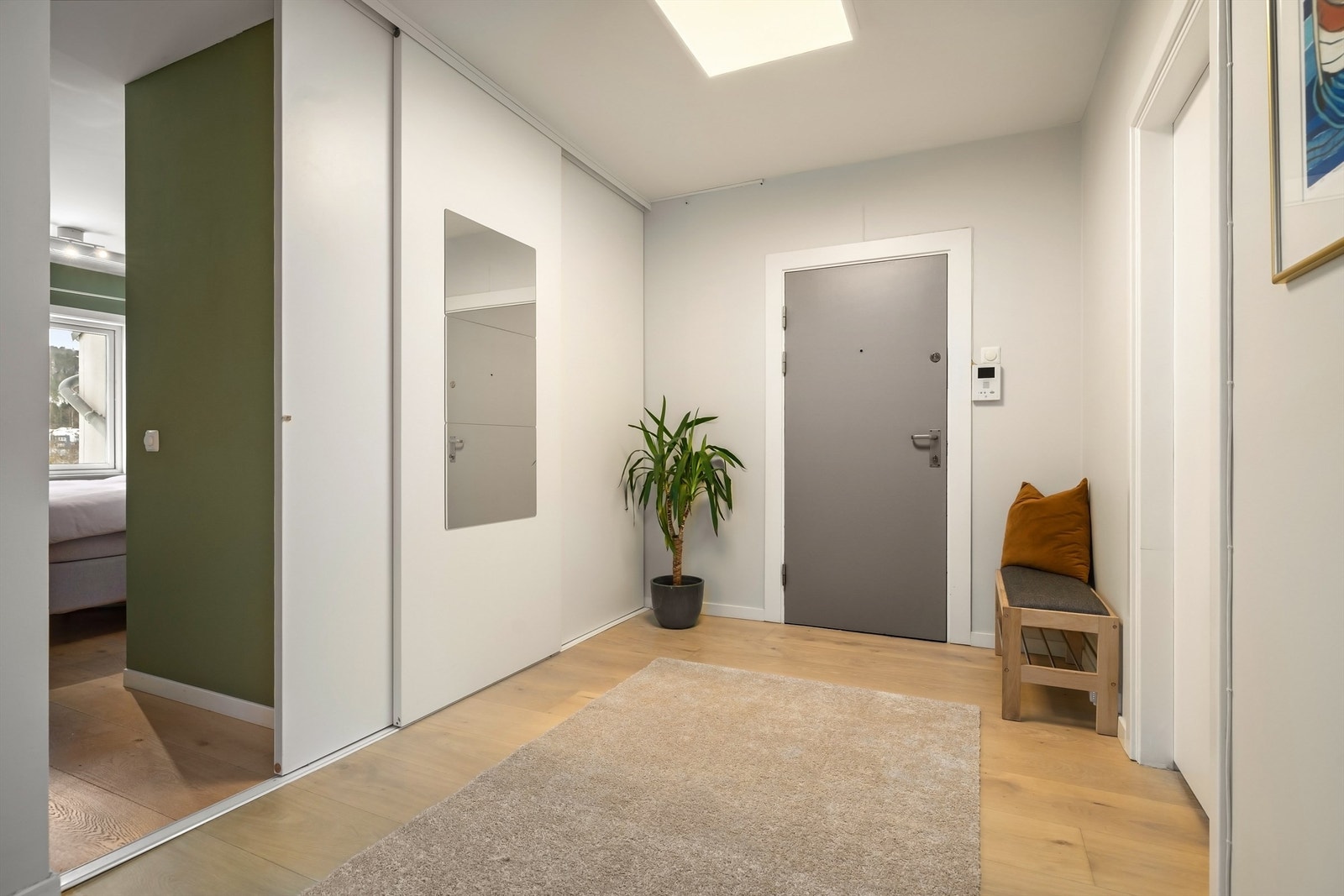 Entréens veggflater er malt i en lys farge og på gulvet er det nyslipt, enstavs parkett Galleribilde