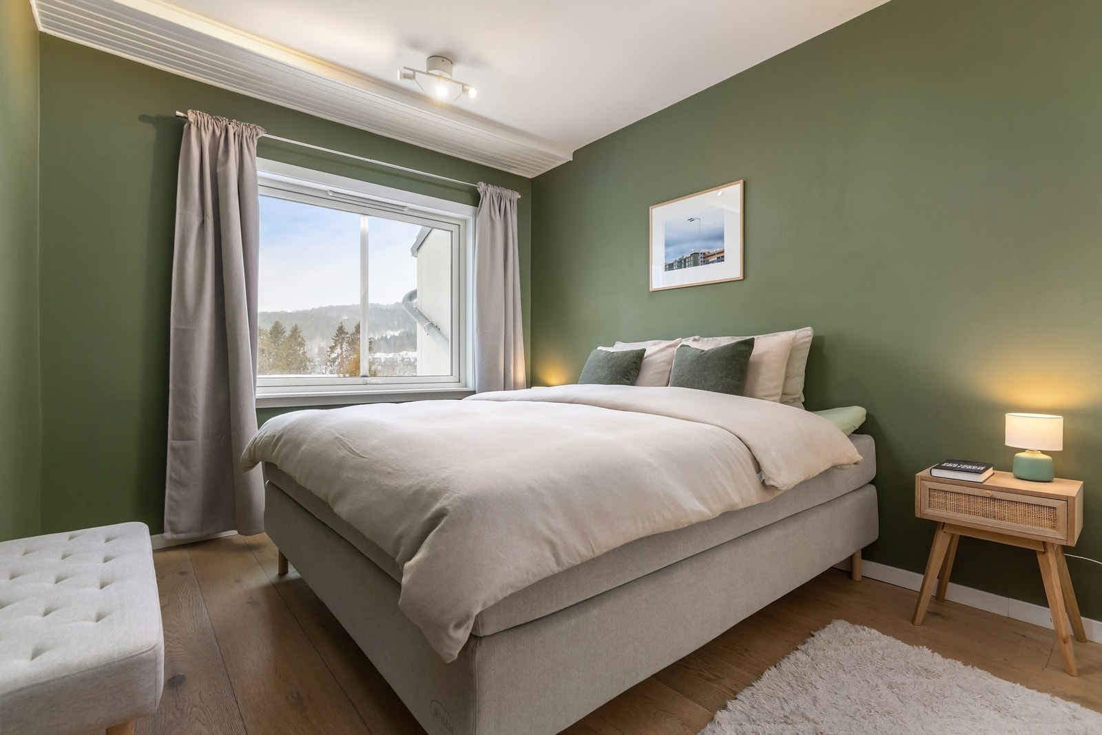 Romslig soverom av god størrelse som byr på plass til stor dobbeltseng og tilhørende nattbord Galleribilde