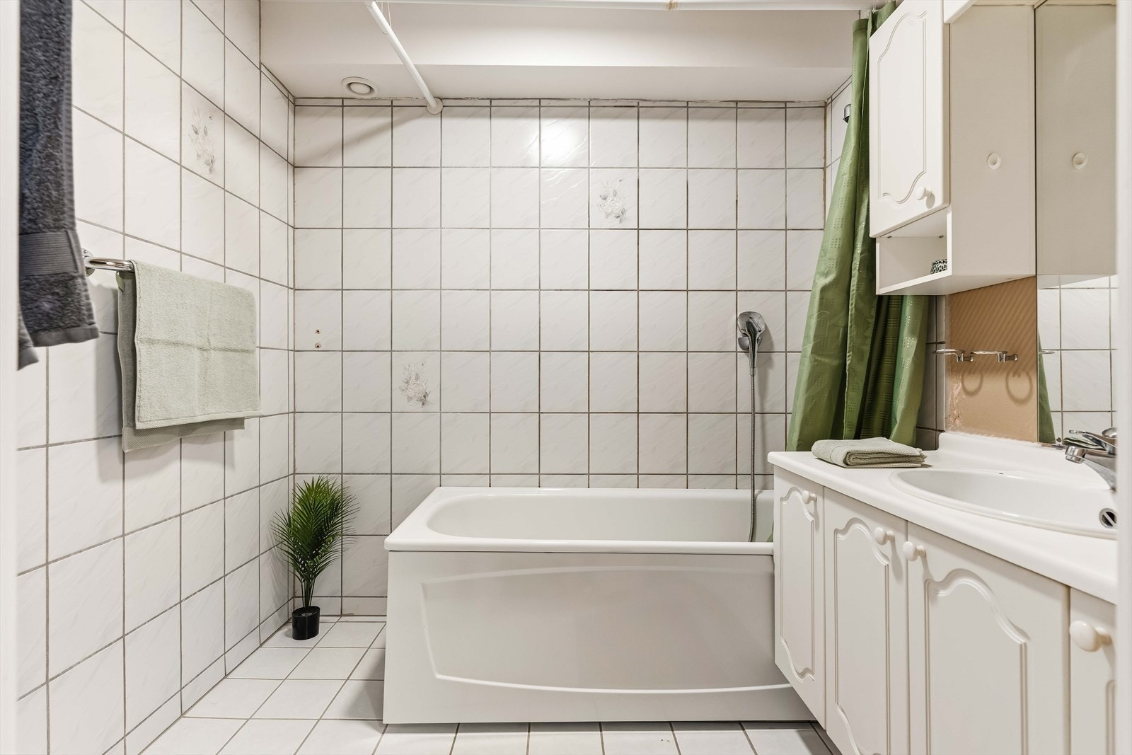 Lyst og flislagt baderom med god oppbevaringsplass i servantinnredningen. Galleribilde