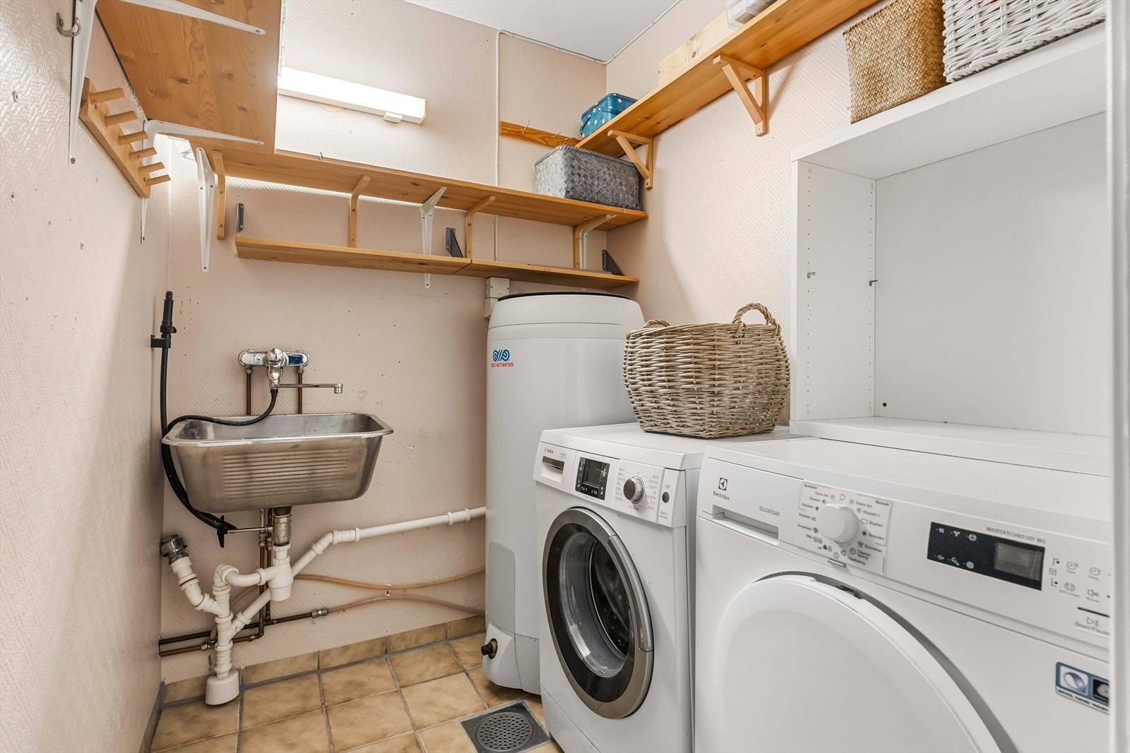 Praktisk vaskerom med utslagsvask og opplegg for vaskemaskin og tørketrommel. Galleribilde
