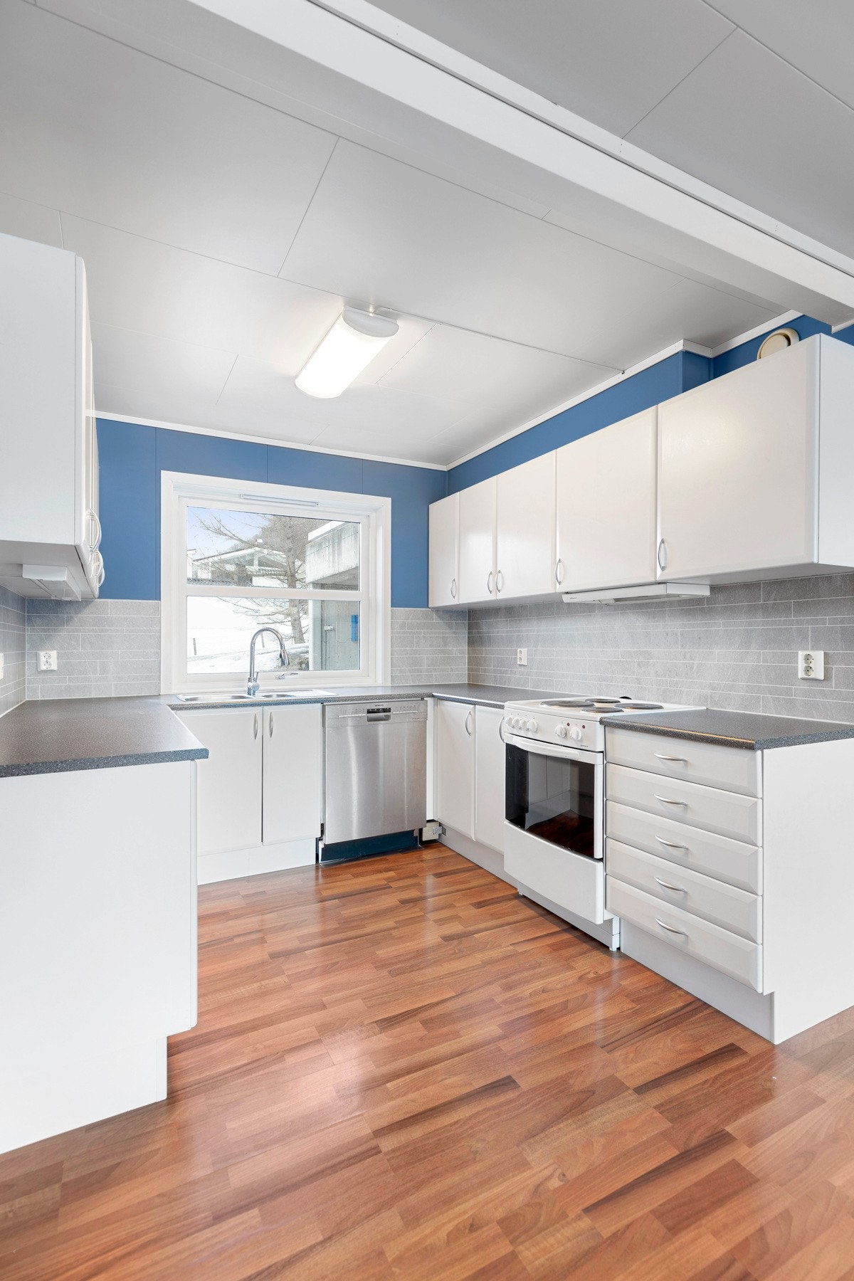 Åpen kjøkkenløsning med innredning i slette fronter. Galleribilde